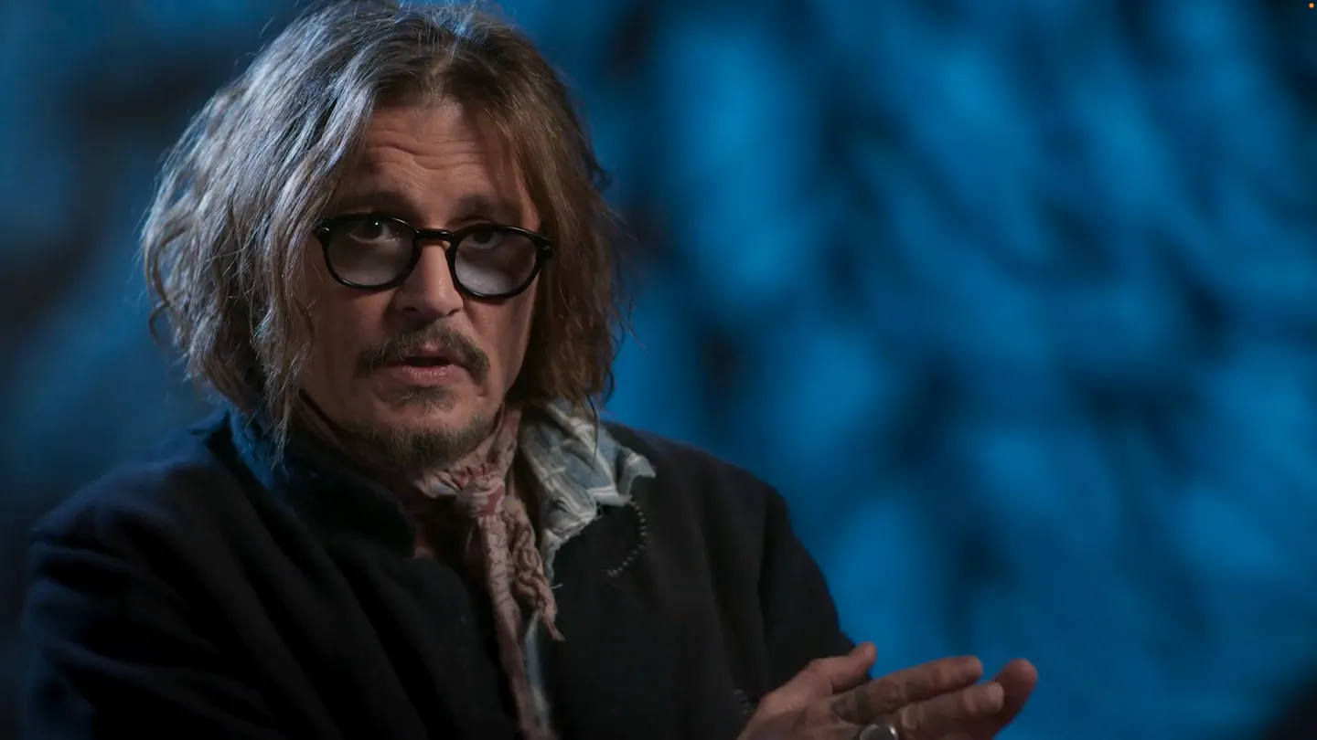 Tim Burton: Life in the Line — an interview subject in round glasses and a scarf speaks against a deep blue backdrop. Original score by Orlando Pérez Rosso, episodes 3 and 4.